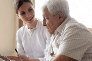 a woman helping an older man review health insurance plans