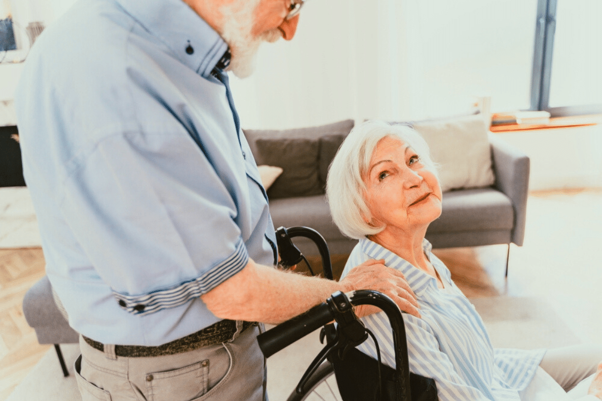 older adult pushed in a wheelchair by their loved one