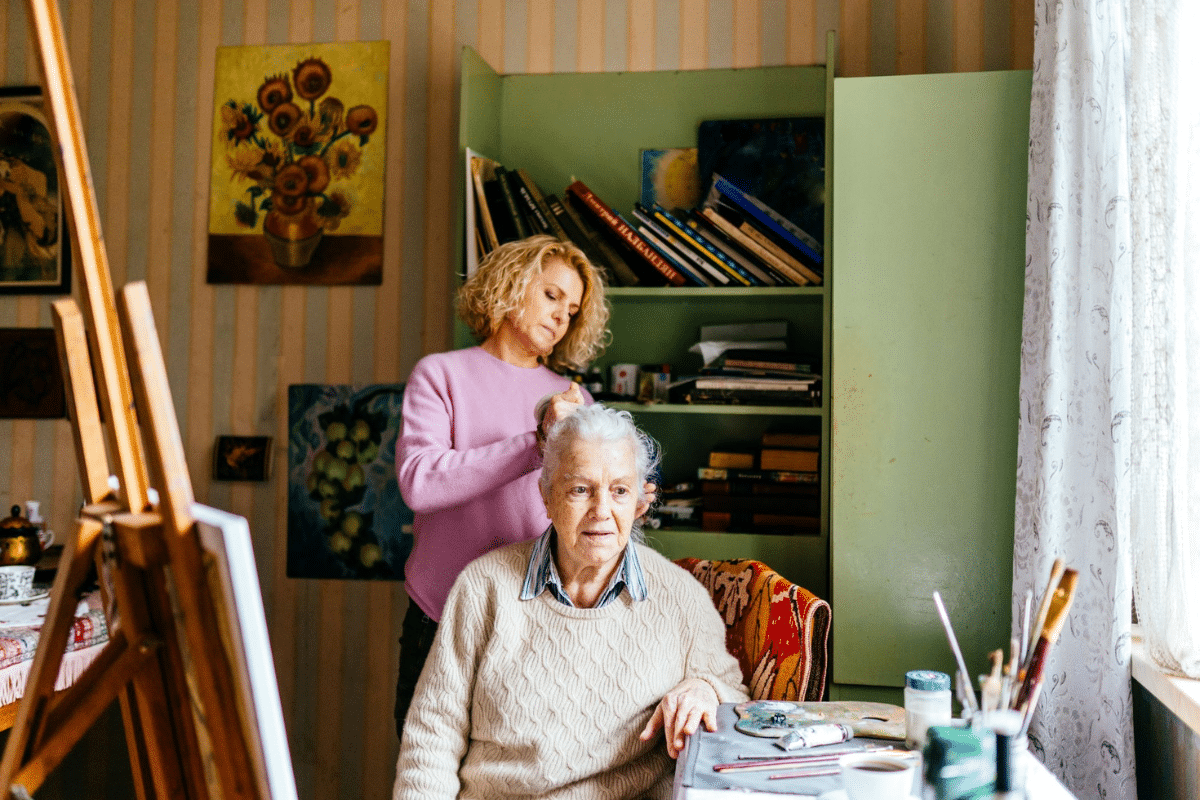 A woman fixes her elderly mother's hair