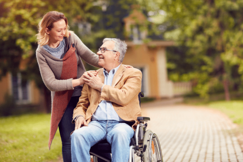 adult woman with her senior father in a wheelchair