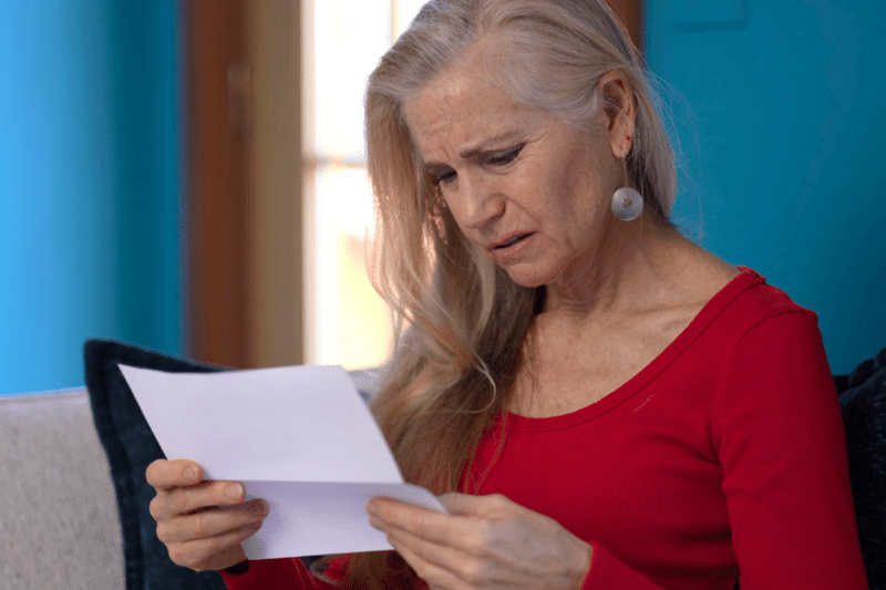concerned older woman reading mail
