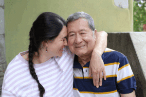 Daughter with arm lovingly over her father