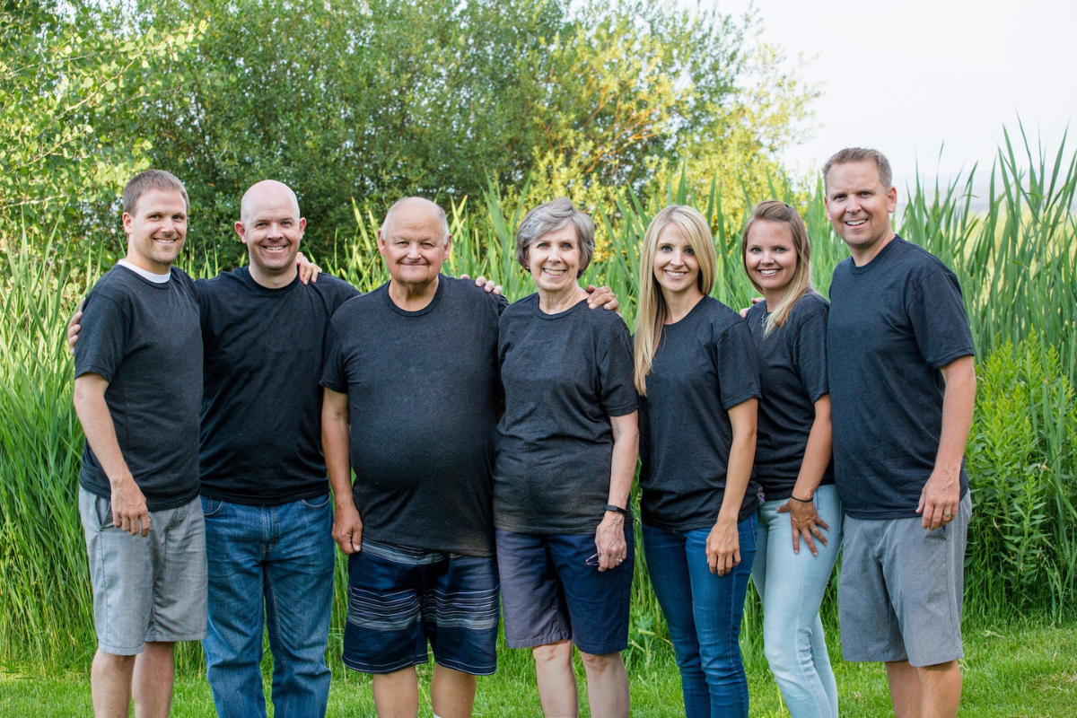 family wearing matching black tshirts stand together for a photo