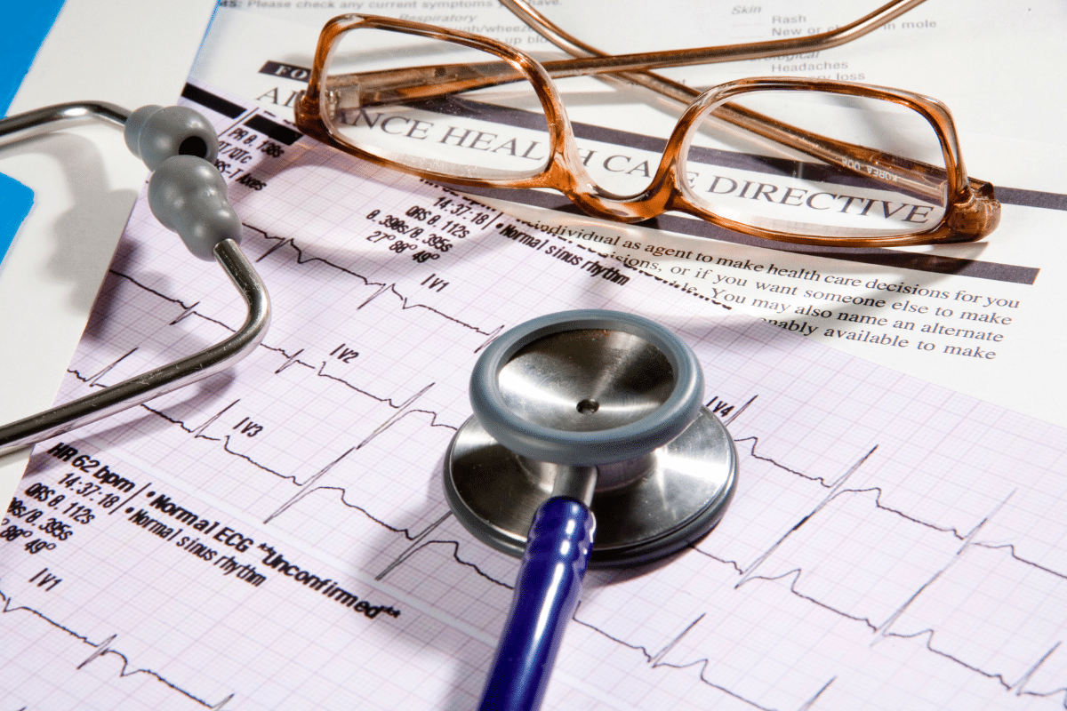 Health Care Directive paperwork underneath a pair of glasses and a stethoscope