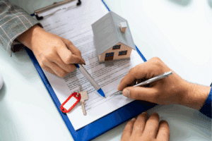 a pair of hands signing a property deed