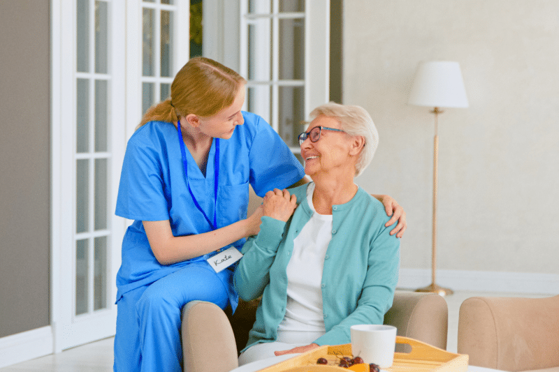 older adult sitting with nurse