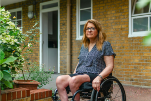 older adult in wheelchair outside her front door