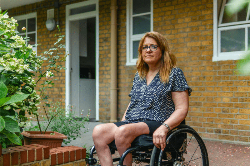 older adult in wheelchair outside her front door