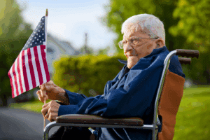 Veteran in a wheelchair holding a US flag